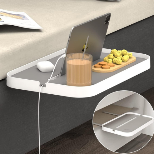Tablette de chevet avec support glissé sous un matelas, portant tablette et verre.
