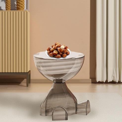 Table d’appoint fumée à plateau rond, avec une assiette de fruits dans un salon.