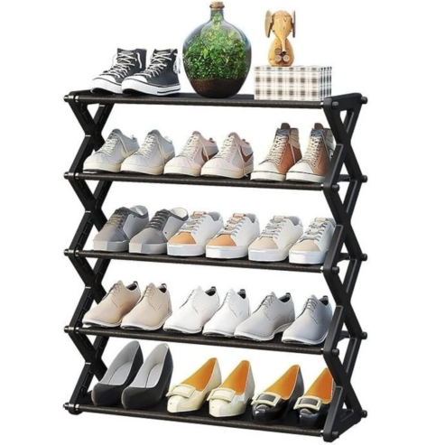 Étagère à chaussures noire à plusieurs niveaux, garnie de chaussures et de décoration.