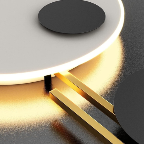 Gros plan sur un disque blanc rétroéclairé et une barre dorée de l’applique.