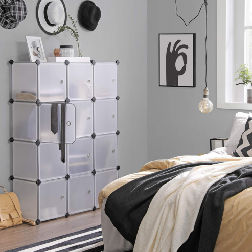 Rangement modulable blanc à plusieurs compartiments installé dans une chambre.