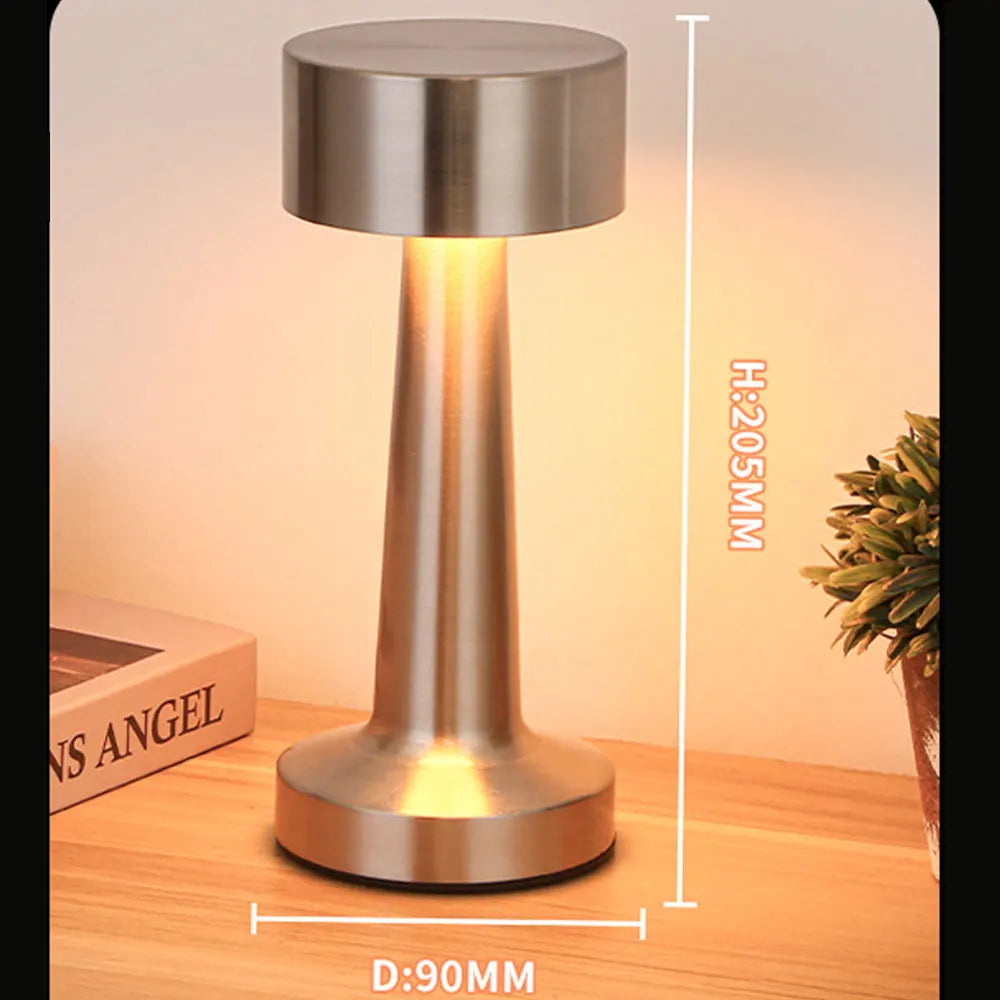 Lampe de table argentée allumée avec repères de dimensions sur le visuel.