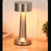 Lampe de table argentée allumée, présentée dans un intérieur.