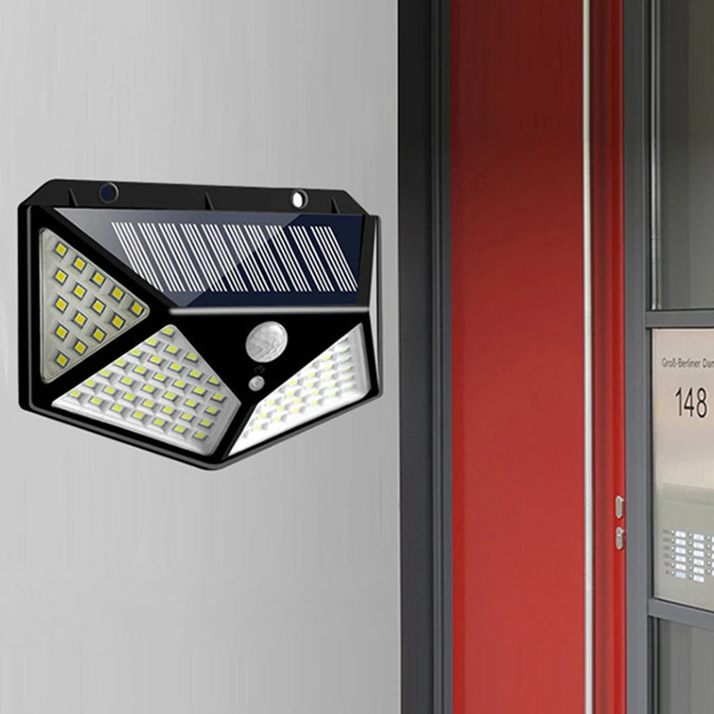 Applique solaire noire fixée sur un mur à côté d’une porte.